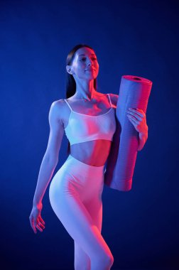 Ön manzara. Paspası tutuyorum. Spor elbiseli genç bayan stüdyoda neon ışıklarıyla bekliyor..