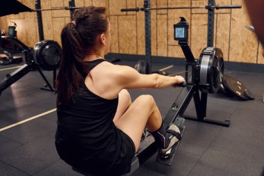 Spor salonunda kürek çeken sporcu bir kadın..
