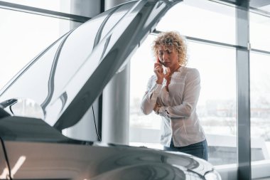 Araç arızası. Kıvırcık sarı saçlı kadın otosalonda..