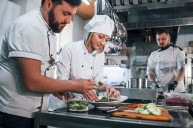 Takım salata yapıyor. Profesyonel aşçı mutfakta yemek hazırlıyor..