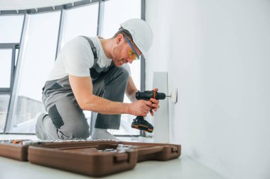 Yan görüş. Tamirci modern odada kapalı alanda çalışıyor..