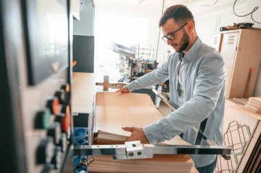 Ahşap çarşaflarla çalışmak. Beyaz elbiseli, matbaadaki adam içeride..