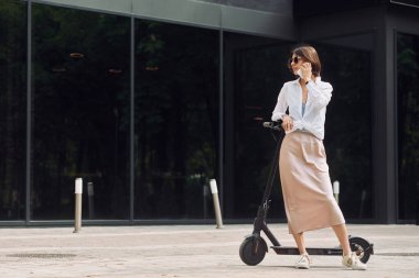 Telefonla. Güzel, genç bir bayan dışarıda motosikletiyle bekliyor..