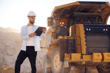 Gözlüklü ve üniformalı akıllı adam gündüz taş ocağında çalışıyor..