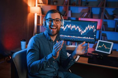 Oturup kameraya bakıyorum. Hisse senedi tüccarı kapalı alanda bilgisayar başında çalışıyor. Değişim ve para kavramı.