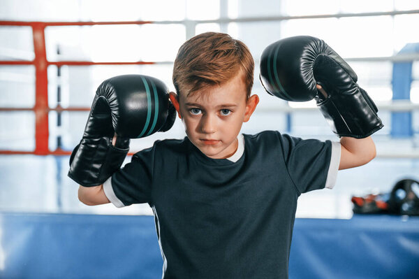Портрет мальчика, практикующего бокс в спортзале с блестками на руках.