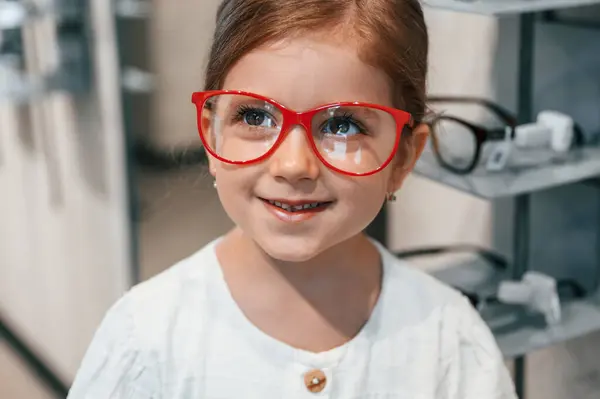 stock image Portrait of little girl that is in the glasses store choosing eyewear.