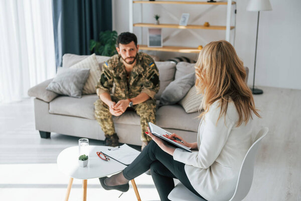 Having conversation. Soldier have therapy session with psychologist indoors.