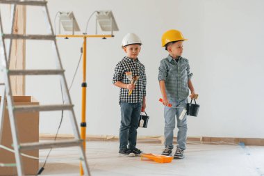 Neşeli çocuklar. İki çocuk ev odasında duvar boyuyor..