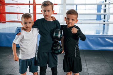 Durup kameraya poz vermek. Erkekler spor salonunda boks antrenmanı yapıyor..