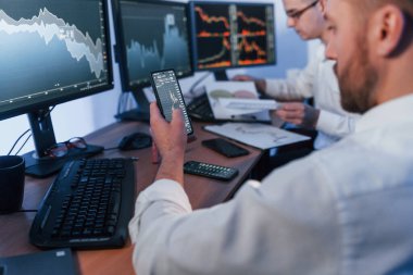 Ofiste değişim teknolojisiyle çalışan iki borsacı..