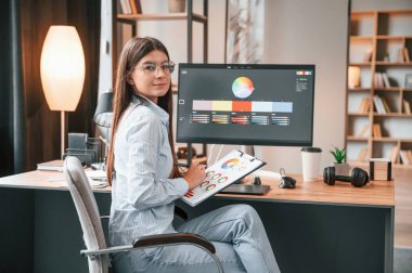 Bilgisayar ve grafik tabletleriyle çalışan genç bir bayan rötuş görevlisi.