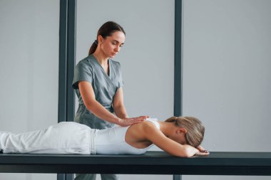 Arkaya masaj yapıyorum. Kadın sağlık merkezinde doktordan yardım alıyor..