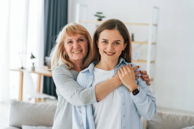 Kamera için poz vermek. Anne ve kızı evde birlikteler..