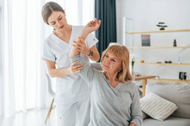 Elle çalışmak. Kıdemli kadın muayenehanedeki doktoru ziyaret ediyor..