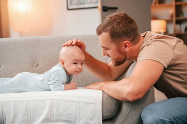 Kafasını okşuyor. Yeni doğmuş bebeğiyle baba içeride. Bekar baba kavramı.