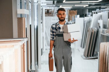 Ekipmanlarla. Tarz sahibi güzel adam ev için malzeme deposunda..