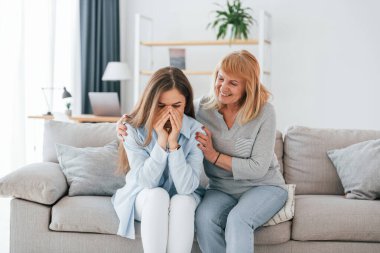 Bir kadını desteklemek ve gülümsemek. Anne ve kızı evde birlikteler..
