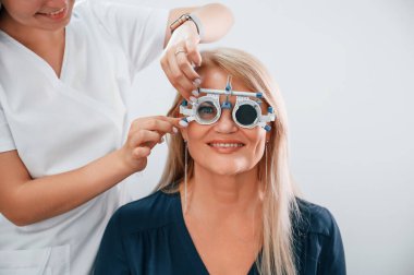 Gözlük takıyordu. Kadının görüşü özel bir cihaz kullanan klinik çalışanı tarafından test ediliyor..