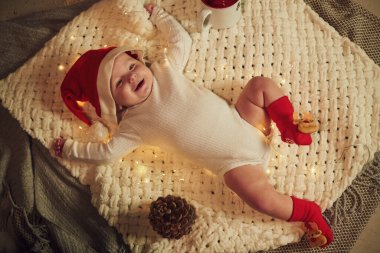 Küçük bebek yerde uzanıyor. Noel elbiseleriyle. Yeni yıl kavramı.