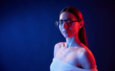 Göz giysisiyle. İçerideki neon ışıkta duran genç bir kadının portresi..