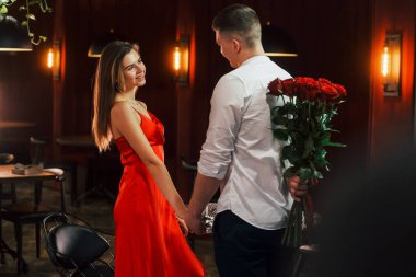 Erkekler çiçek verir. Romantik çift restoranda yemek yiyor..