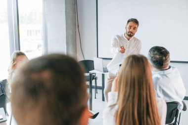 İnsanoğlu öğretmenlik yapıyor ve master yapıyor. Profesyonel iş adamlarından oluşan bir grup ofiste..