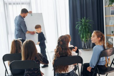 Okulda öğretmenle birlikte bir grup çocuk öğrenci..