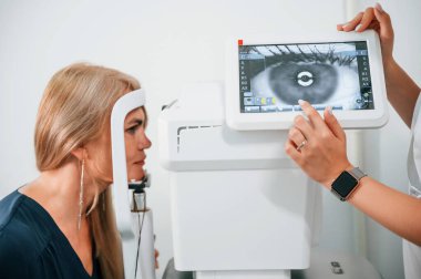 Yan görüş. Kadının görüşü özel bir cihaz kullanan klinik çalışanı tarafından test ediliyor..