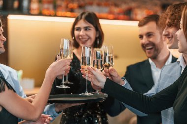 Birlikte oturuyoruz. Bir grup şık giyinmiş insan restoranda kutlama yapıyor..