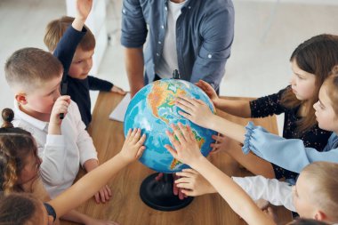 Dünya 'ya dokunmak. Okulda öğretmenle birlikte bir grup çocuk öğrenci..