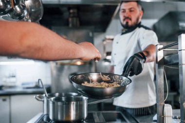İçindekileri döküyorum. Profesyonel aşçı mutfakta yemek hazırlıyor..