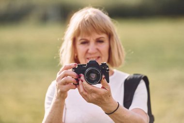 Kamerayı kullanarak. Fotoğrafları hazırlıyorum. Sunny Day 'de son sınıf öğrencisi dışarıda güzel bir hafta sonu geçiriyor..
