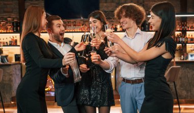 Şampanya ve maytap. Güzel giyinmiş bir grup insan içeride yeni yılı kutluyorlar..