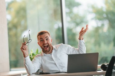 Başarılı olmak. Resmi kıyafetli adam modern ofiste çalışıyor..