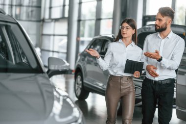 Ön manzara. Beyaz elbiseli bir adam araba galerisinde birlikte..