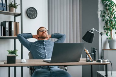 Mola verdim. Adam modern büroda çalışıyor. İş ve serbest meslek anlayışı.