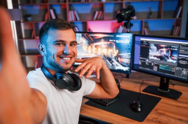 Selfie çekmek, zaferi kutlamak. Günlük giysiler içindeki erkek oyun flaması içeride bilgisayar ile birlikte..