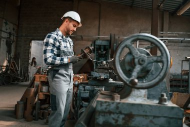 Metal işleme. Üniformalı fabrika çalışanı içeride..