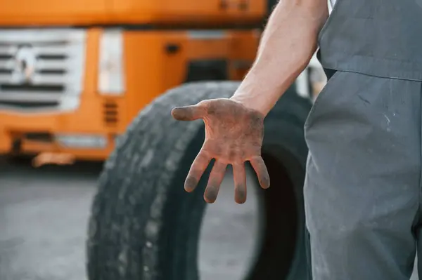 stock image Showing dirty hands. Man in unifrom doing service for big truck vehicle.