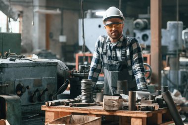 Kasketli. Üniformalı fabrika çalışanı içeride..