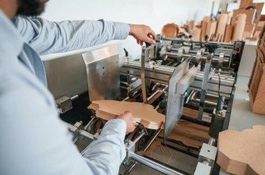 Matbaa kesme makinesi. Beyaz elbiseli matbaacı içeride..