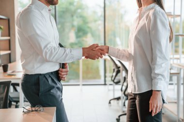 Tokalaşıyorum. Erkek ve kadın modern ofiste birlikte çalışıyorlar..