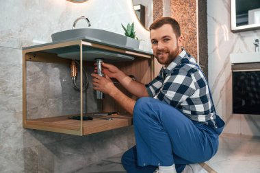 Mavi üniformalı bir işçi tuvalette..