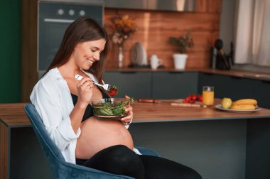 Mutfakta salata yiyorum. Güzel hamile kadın evde..