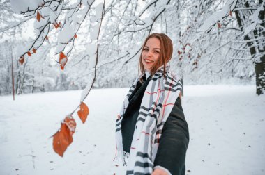 Yolu gösteriyorum. Güzel genç bir kadın kış ormanında dışarıda..