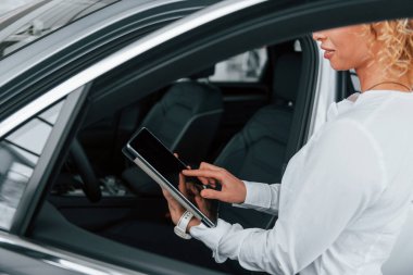 Aracın iç görüntüsü. Kıvırcık sarı saçlı kadın otosalonda..