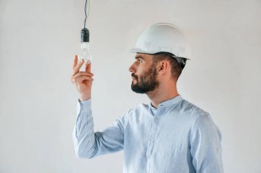 Parlak odada ampulle. Adam dairede tamirat yapıyor..