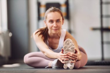 Yoga egzersizleri ve esneme hareketleri. Spor elbiseli genç bir kadın spor salonunda spor yapıyor..