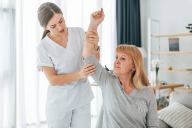 Elle çalışmak. Kıdemli kadın muayenehanedeki doktoru ziyaret ediyor..